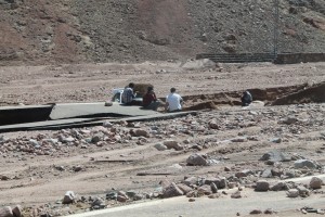 Egyptians sitting around  a massive hole in the road